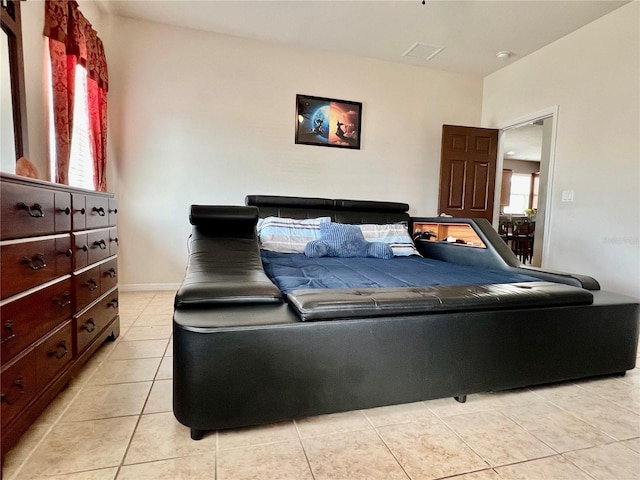 bedroom with light tile patterned floors and baseboards