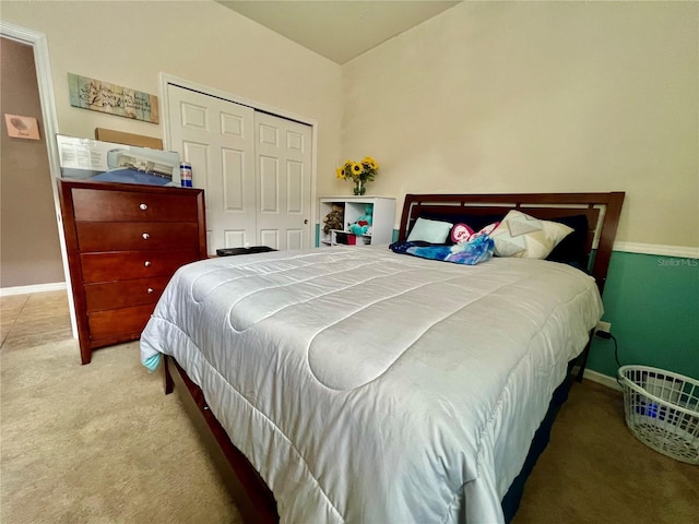 carpeted bedroom featuring baseboards and a closet