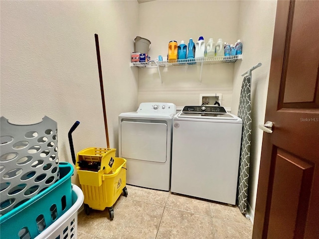 laundry room featuring laundry area, washer and clothes dryer, and light tile patterned flooring