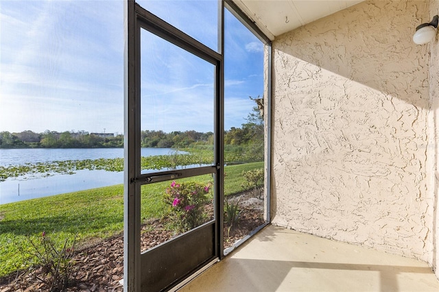 unfurnished sunroom featuring a water view