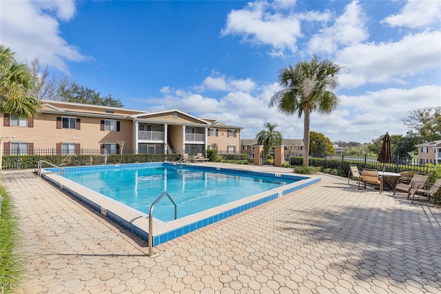 community pool with fence and a patio