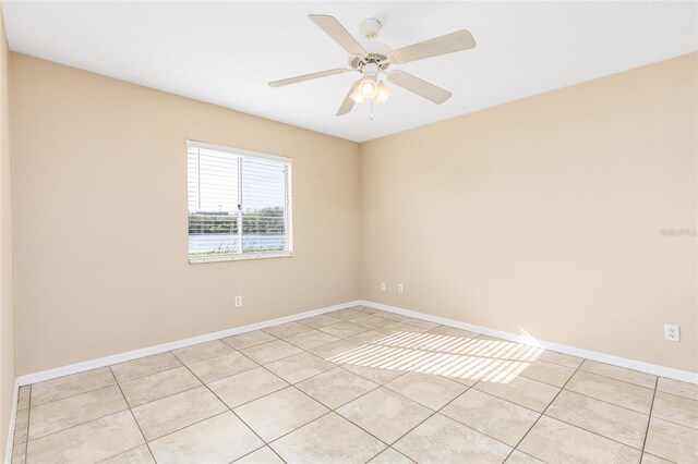empty room with light tile patterned floors, baseboards, and ceiling fan