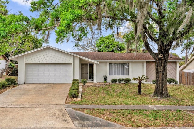 ranch-style home featuring driveway, an attached garage, fence, a front yard, and stucco siding