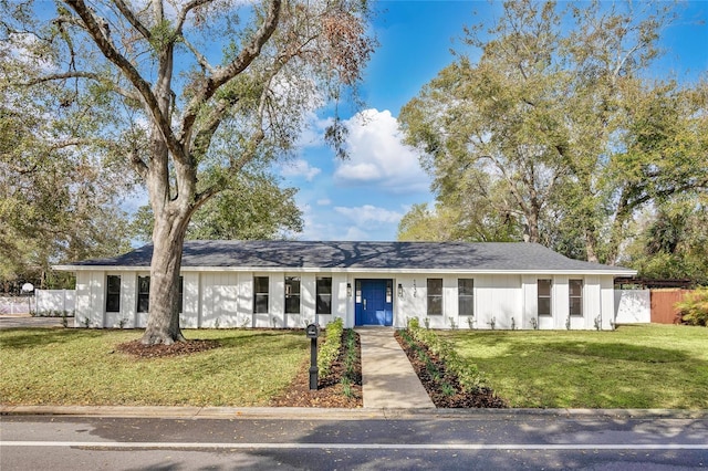 ranch-style house featuring a front yard and fence