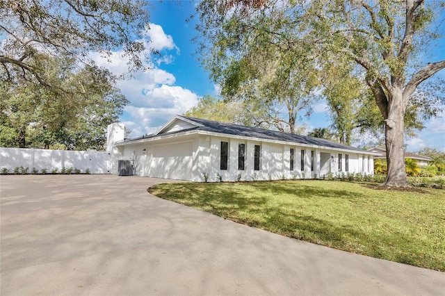 single story home with an attached garage, driveway, fence, and a front lawn