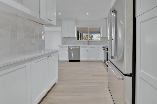 kitchen featuring white cabinetry, appliances with stainless steel finishes, light countertops, and backsplash