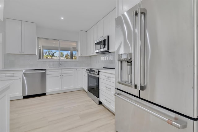 kitchen featuring appliances with stainless steel finishes, white cabinetry, and decorative backsplash