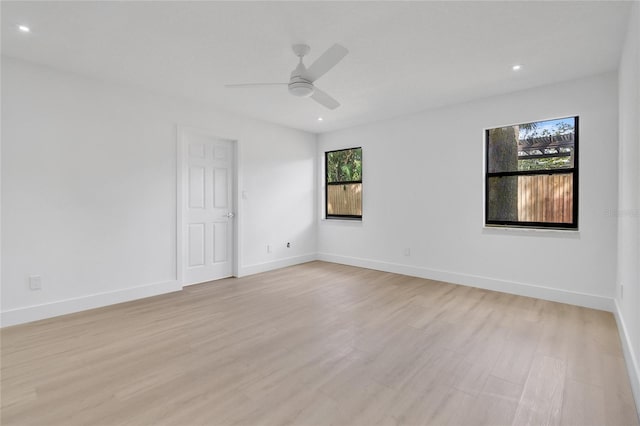 empty room with light wood finished floors, baseboards, a ceiling fan, and recessed lighting