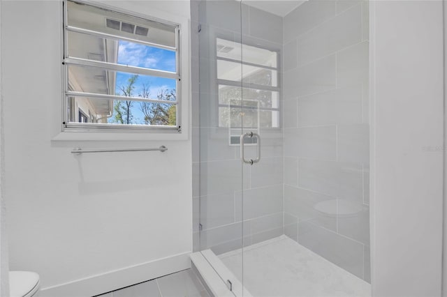 full bathroom featuring baseboards, a shower stall, and toilet