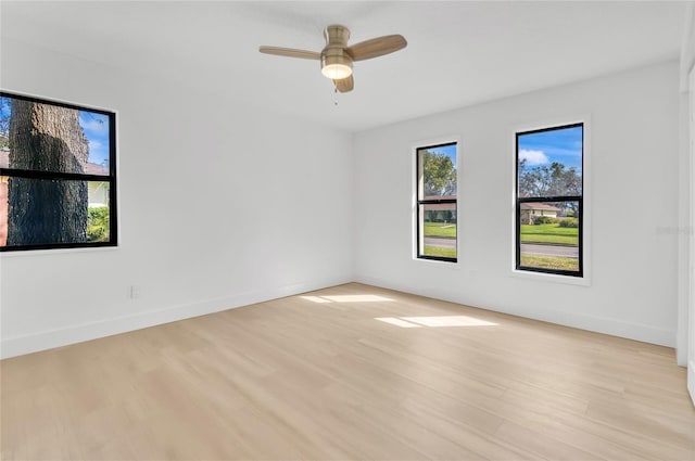 unfurnished room with baseboards, a ceiling fan, and light wood-style floors