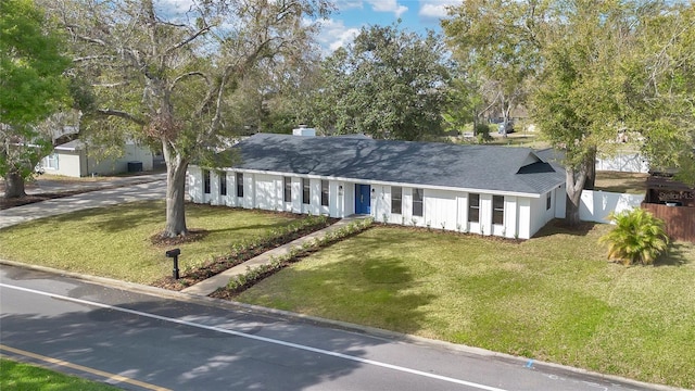 single story home featuring fence, a front lawn, and roof with shingles