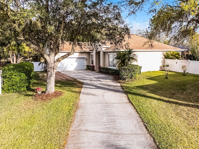 view of front of property featuring stucco siding, concrete driveway, an attached garage, fence, and a front lawn