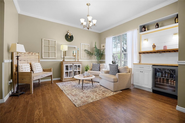 living area featuring wine cooler, ornamental molding, dark wood finished floors, and a chandelier