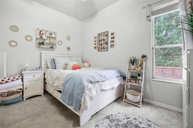 bedroom featuring baseboards and light colored carpet