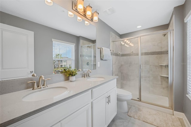 full bath with double vanity, a stall shower, toilet, and a sink