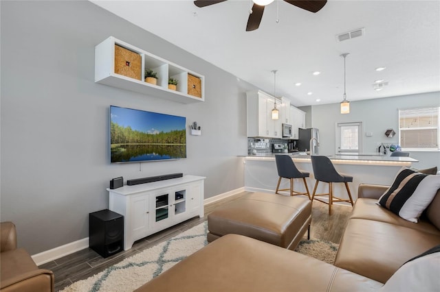 living room with recessed lighting, visible vents, a ceiling fan, wood finished floors, and baseboards