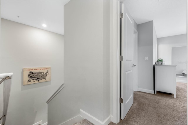 corridor featuring carpet floors, recessed lighting, baseboards, and an upstairs landing