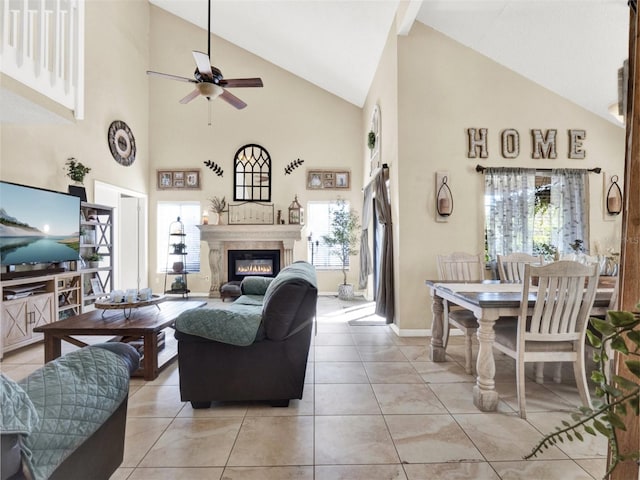 living room featuring a healthy amount of sunlight, light tile patterned floors, ceiling fan, and a glass covered fireplace