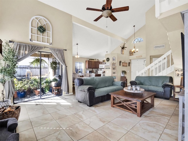 living room featuring stairs, high vaulted ceiling, ceiling fan with notable chandelier, and visible vents