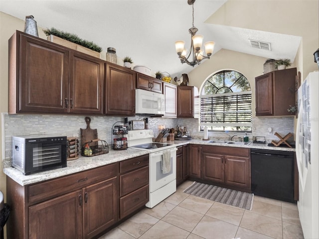 kitchen featuring dark brown cabinetry, white appliances, vaulted ceiling, and a sink