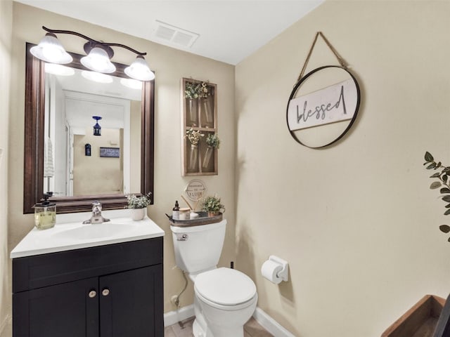 bathroom featuring toilet, baseboards, visible vents, and vanity