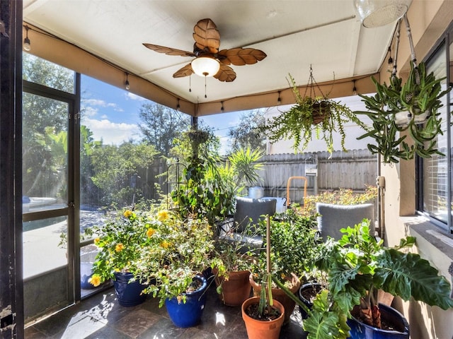 unfurnished sunroom with ceiling fan