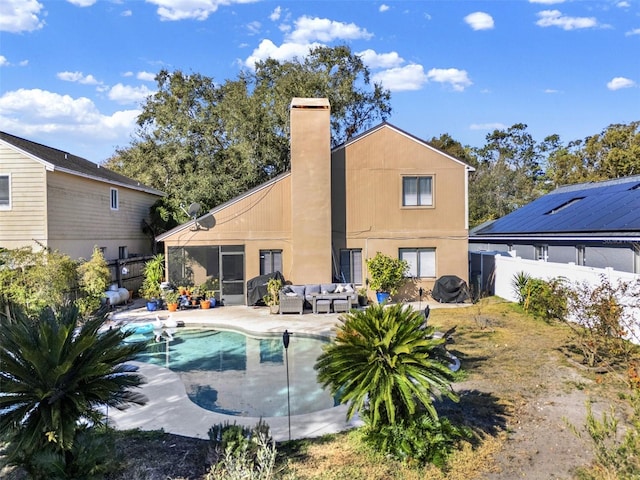 back of property with a fenced backyard, an outdoor hangout area, a fenced in pool, and a patio