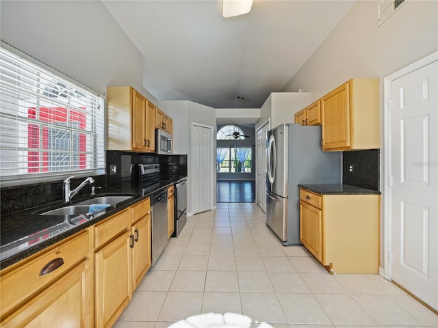 kitchen with a sink, stainless steel appliances, light brown cabinets, backsplash, and light tile patterned flooring