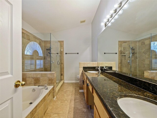 full bath with a stall shower, double vanity, a sink, and a bath