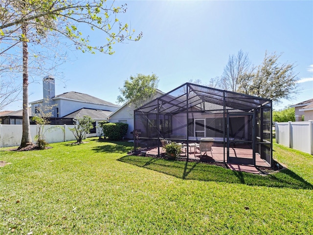 rear view of property with a lanai, a fenced backyard, a yard, and a patio