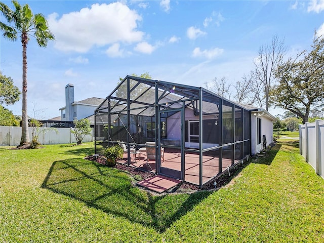 back of house featuring glass enclosure, a fenced backyard, and a patio