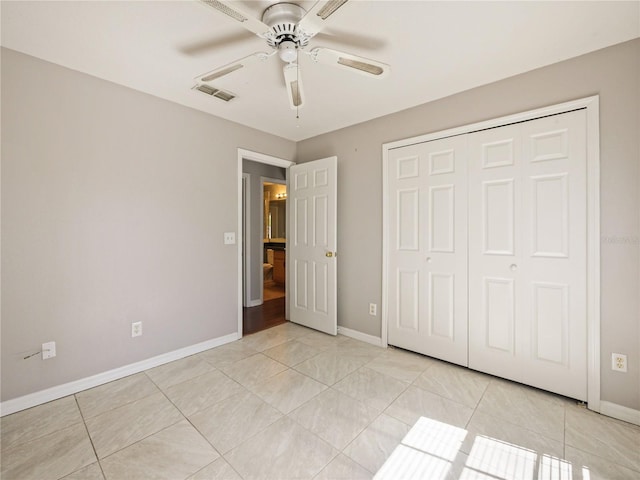 unfurnished bedroom with light tile patterned floors, baseboards, visible vents, and a closet