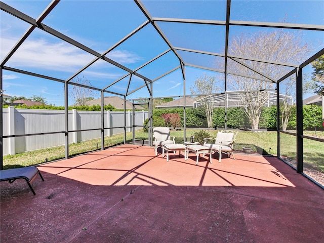 view of patio featuring glass enclosure and fence