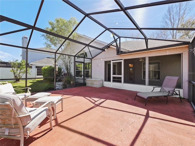 view of patio featuring glass enclosure and fence