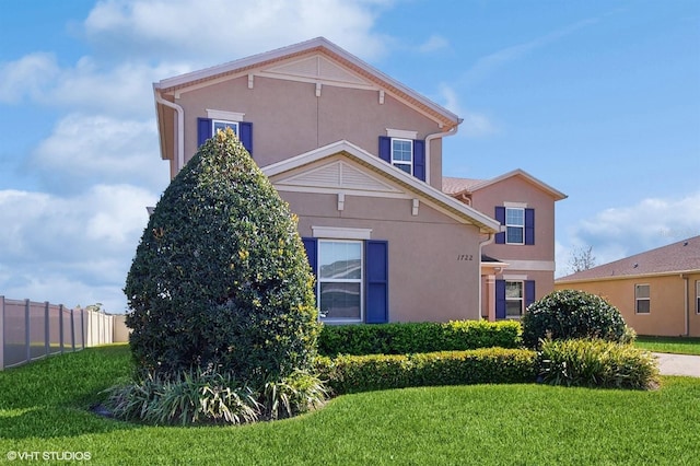 exterior space with a yard, fence, and stucco siding