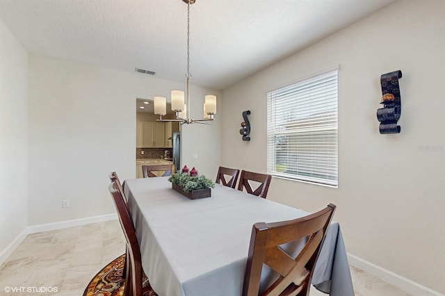 dining room featuring visible vents, a notable chandelier, a textured ceiling, and baseboards