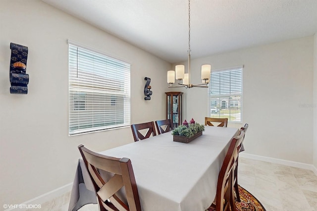 dining space with a notable chandelier and baseboards