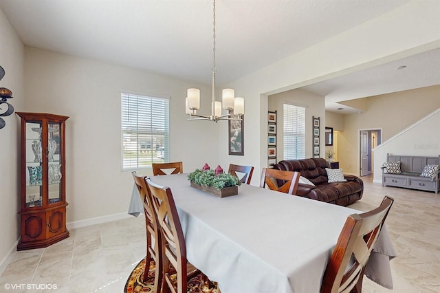 dining room with baseboards and a notable chandelier