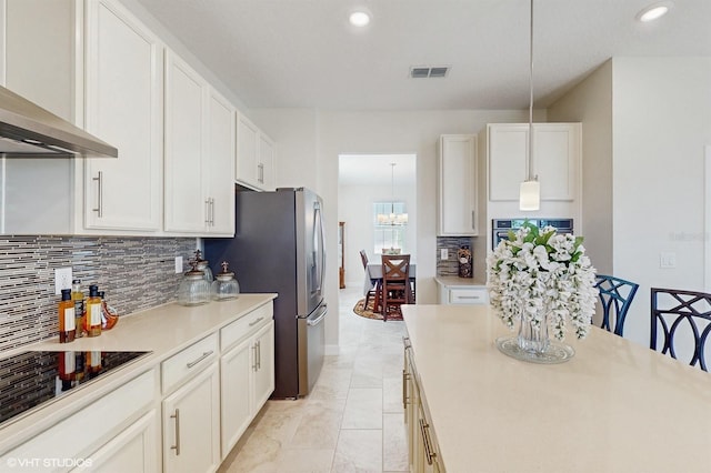 kitchen featuring light countertops, visible vents, appliances with stainless steel finishes, white cabinetry, and wall chimney exhaust hood