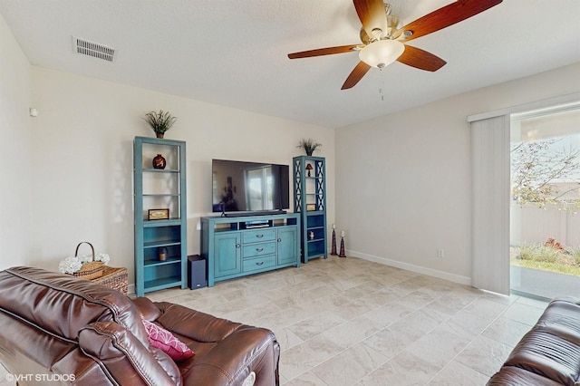 living room with baseboards, visible vents, and a ceiling fan