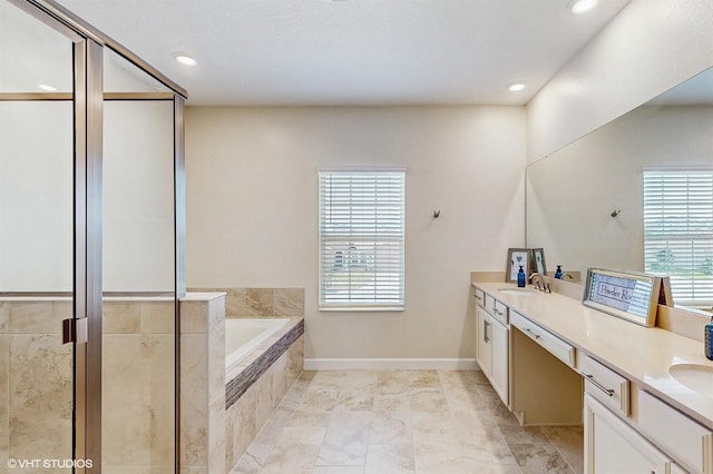 bathroom featuring double vanity, a shower stall, a wealth of natural light, and a bath