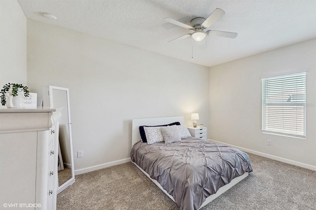 bedroom with light carpet, ceiling fan, a textured ceiling, and baseboards