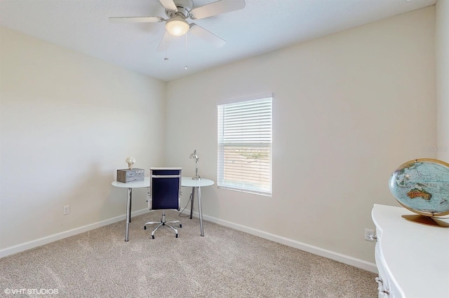 carpeted office featuring a ceiling fan and baseboards