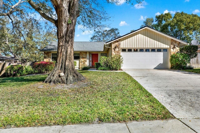 ranch-style home with stone siding, a garage, driveway, and a front yard