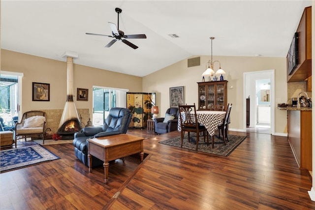 living room featuring a ceiling fan, vaulted ceiling, dark wood-style floors, and visible vents