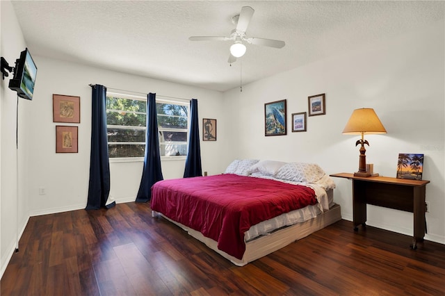 bedroom featuring a textured ceiling, baseboards, and wood finished floors