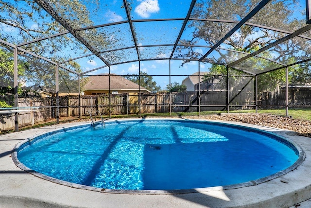 view of pool with a fenced in pool, a fenced backyard, and glass enclosure