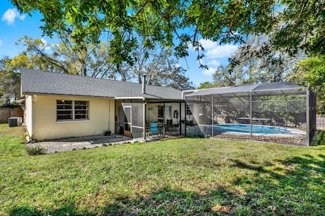 back of house featuring cooling unit, fence, an outdoor pool, stucco siding, and a lawn