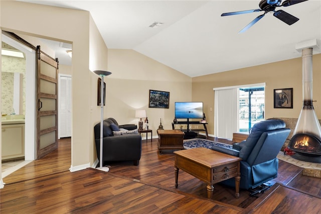 living room with a ceiling fan, wood finished floors, visible vents, lofted ceiling, and a barn door