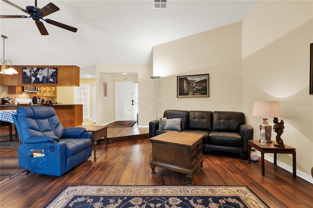 living room featuring ceiling fan, visible vents, baseboards, and wood finished floors